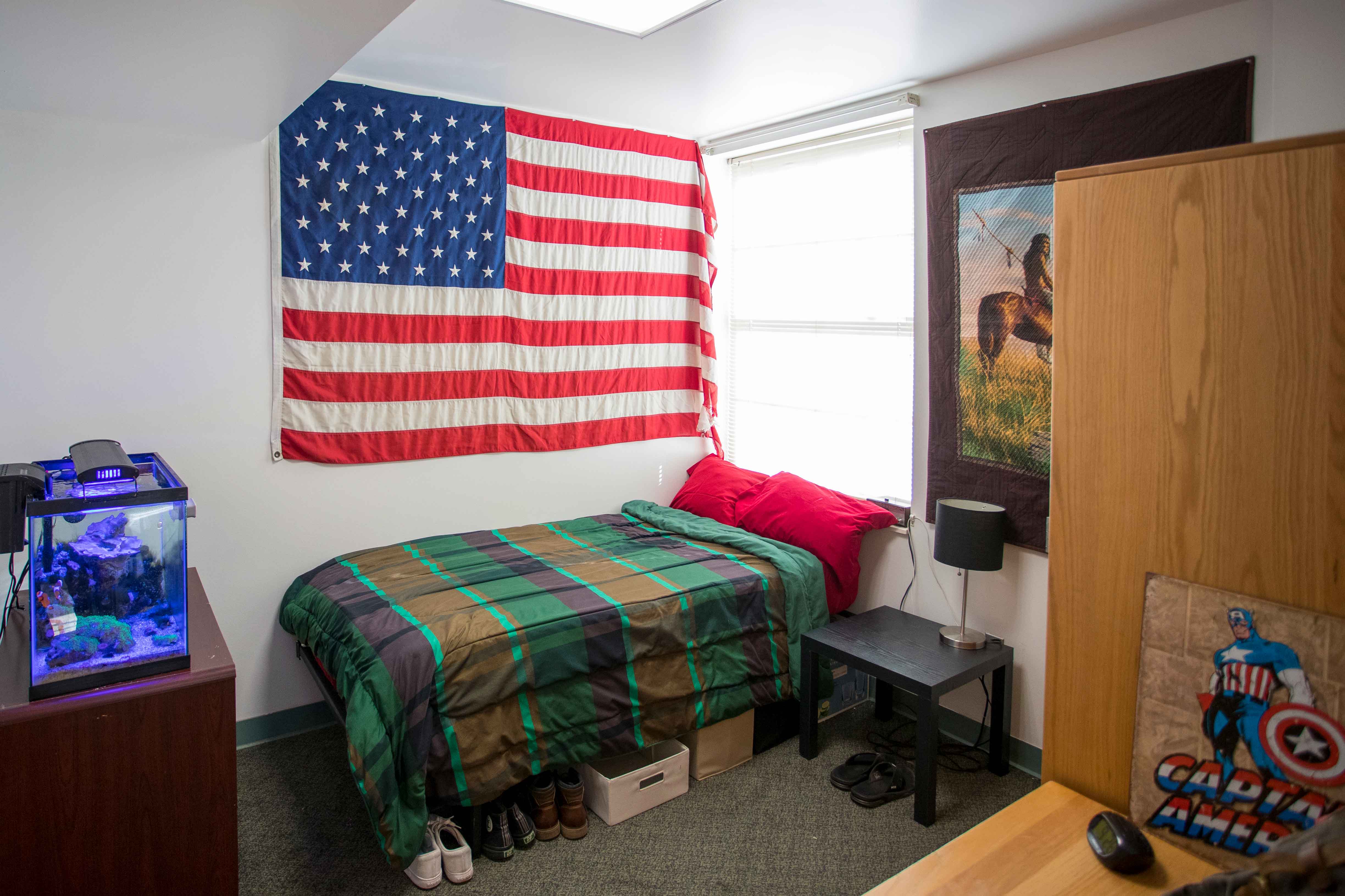 Bennett Hall Bedroom decorated with green sheets and an american flag on the wall