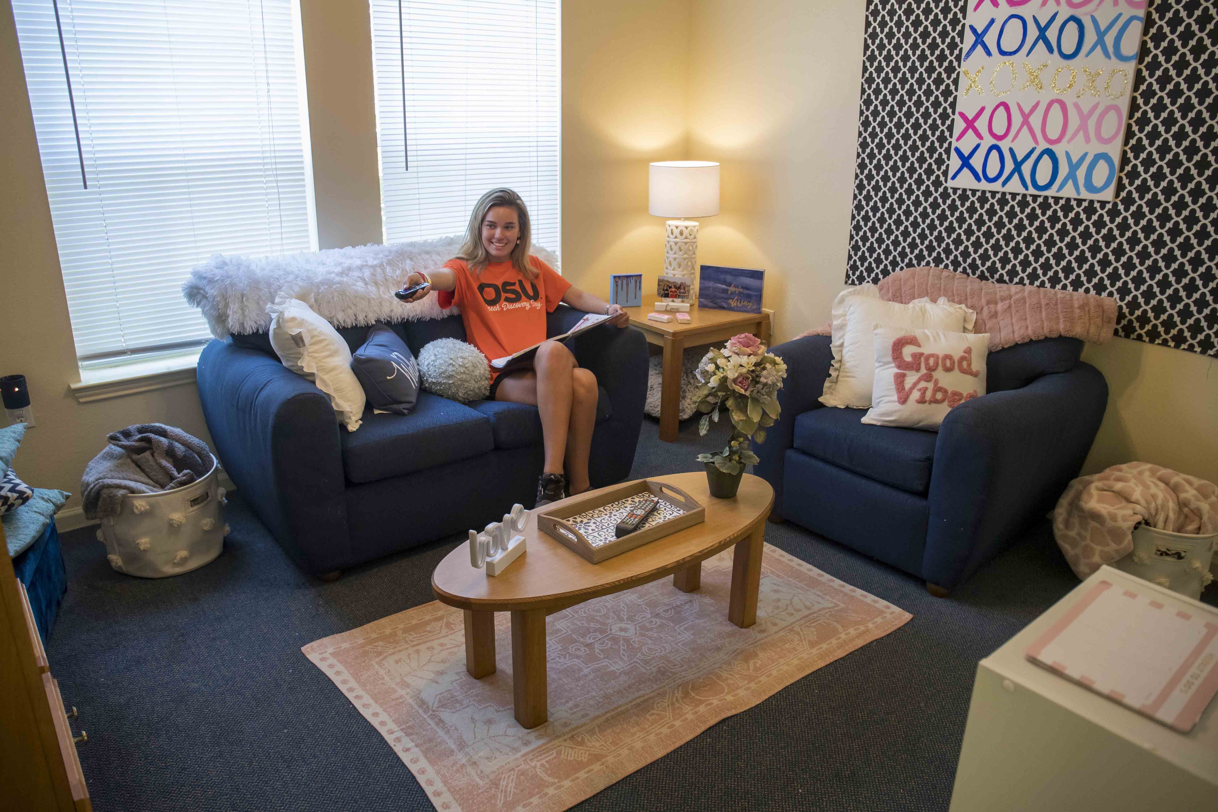 girl sitting on couch similing Booker & Stintchcomb Halls