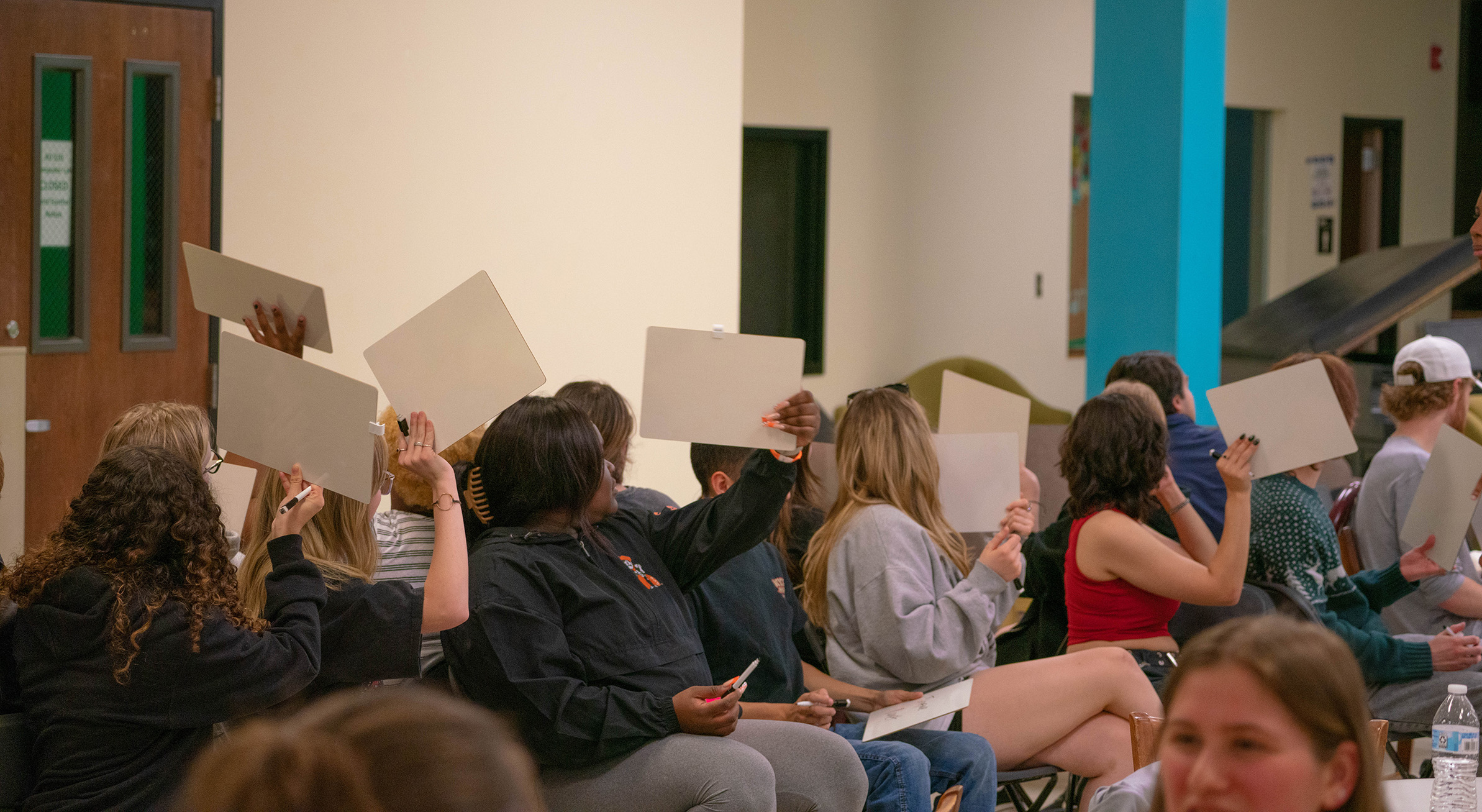students holding up signs at late night event