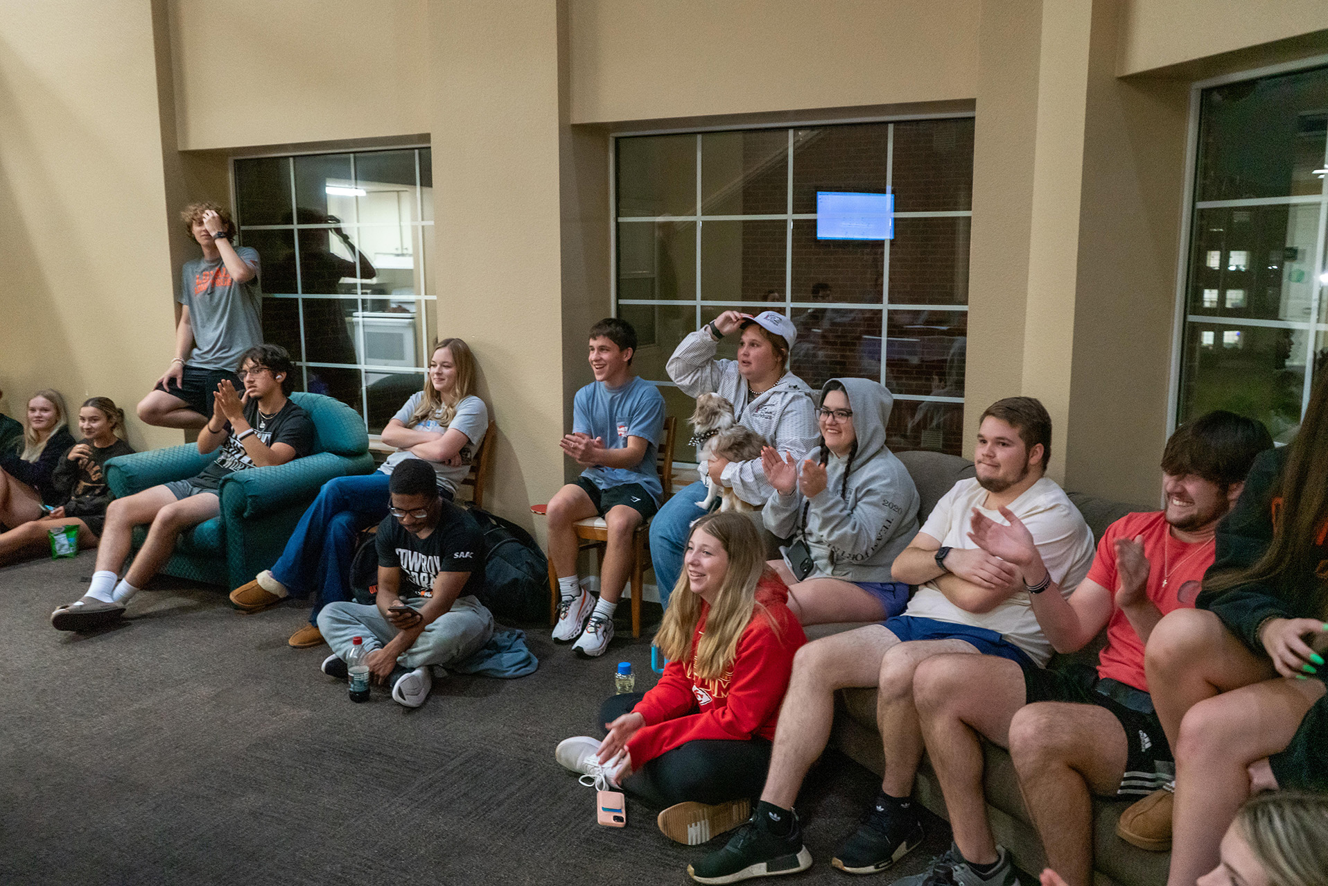 Students sitting around laughing in a lounge at booker hall