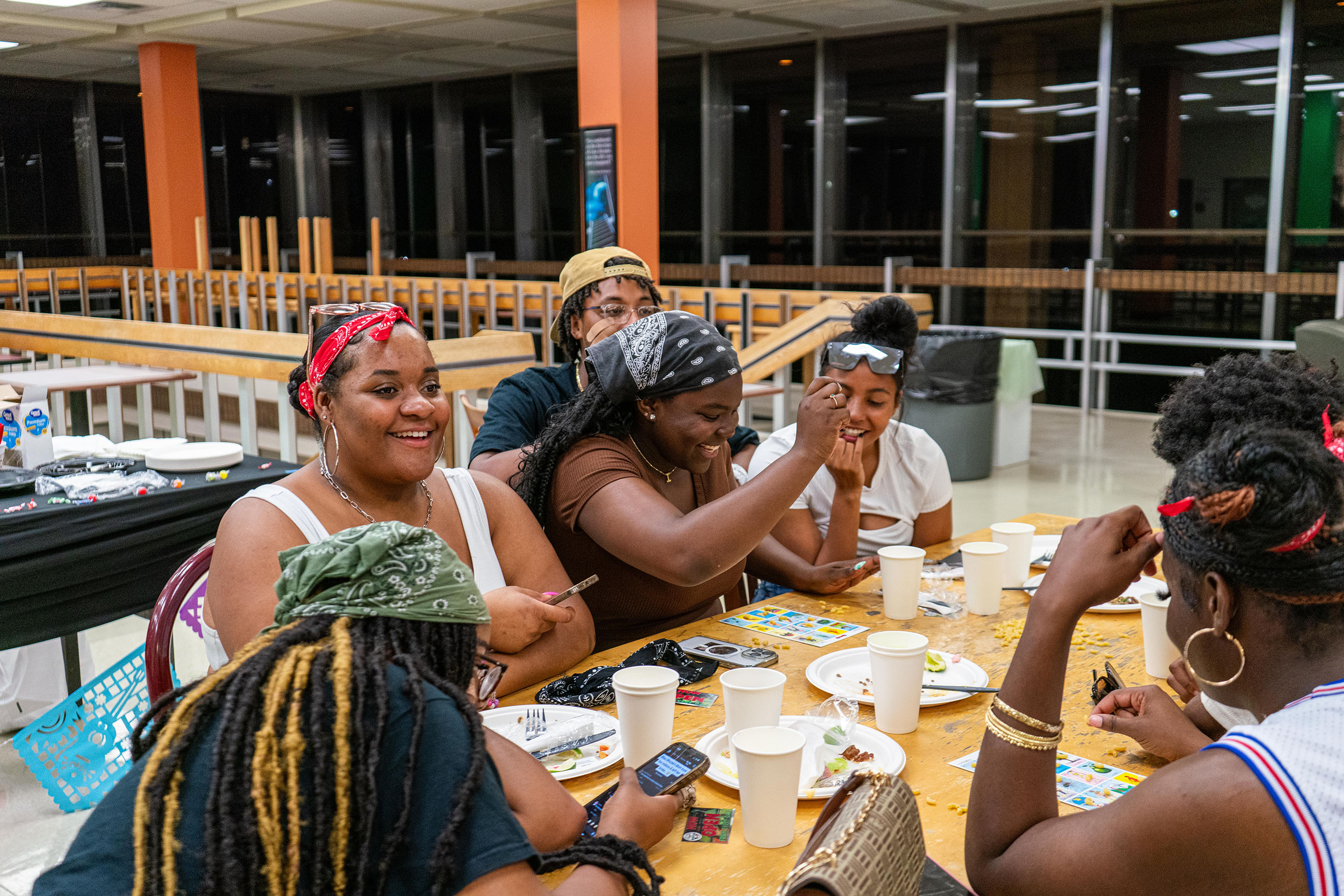 students sitting around table laughing at late night event