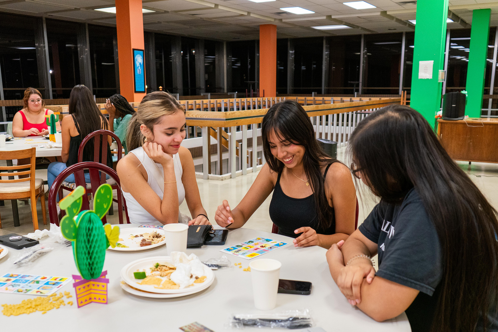 students sitting around table laughing at late night event