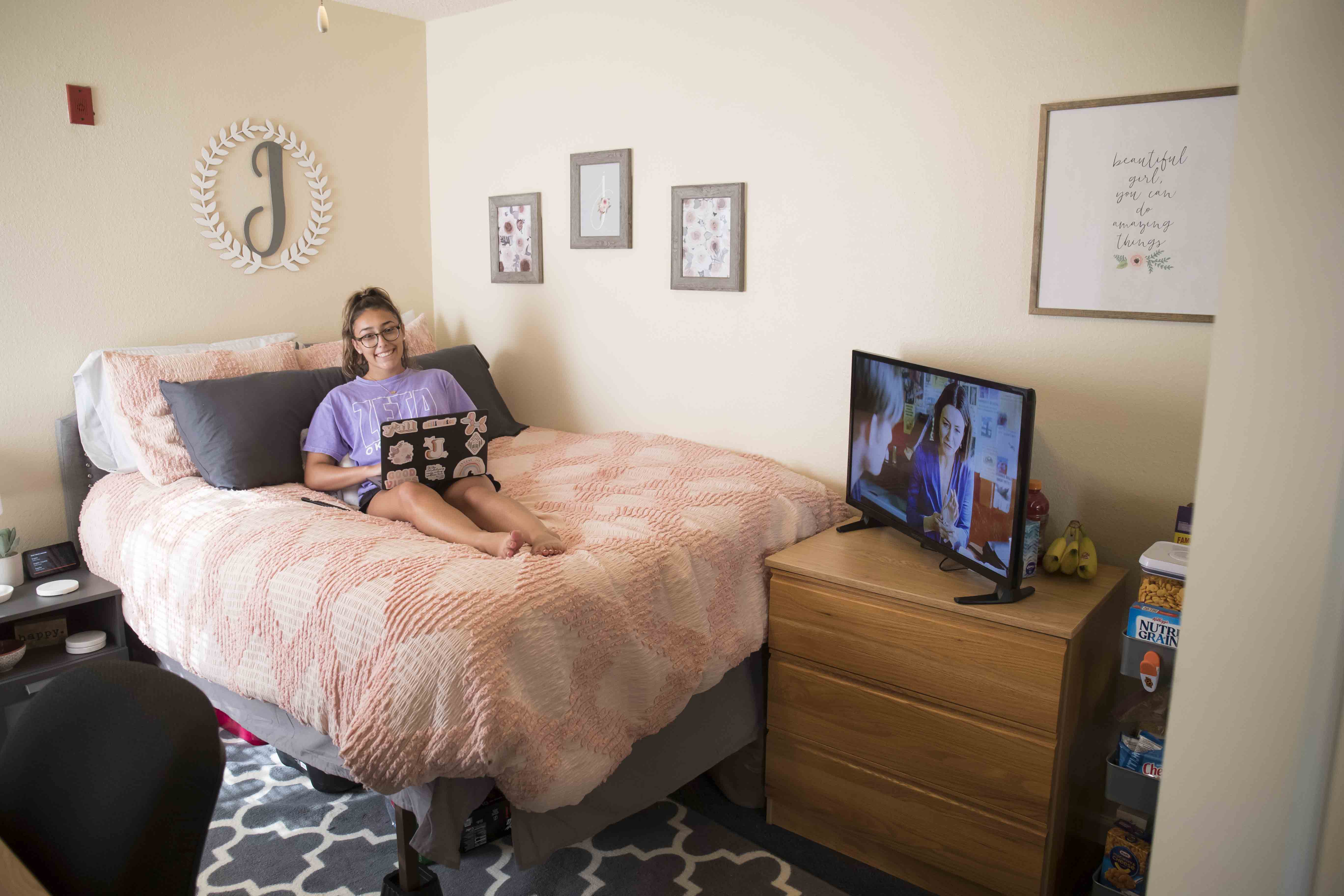 girl sitting on full size bed in Patchin-Jones Hall