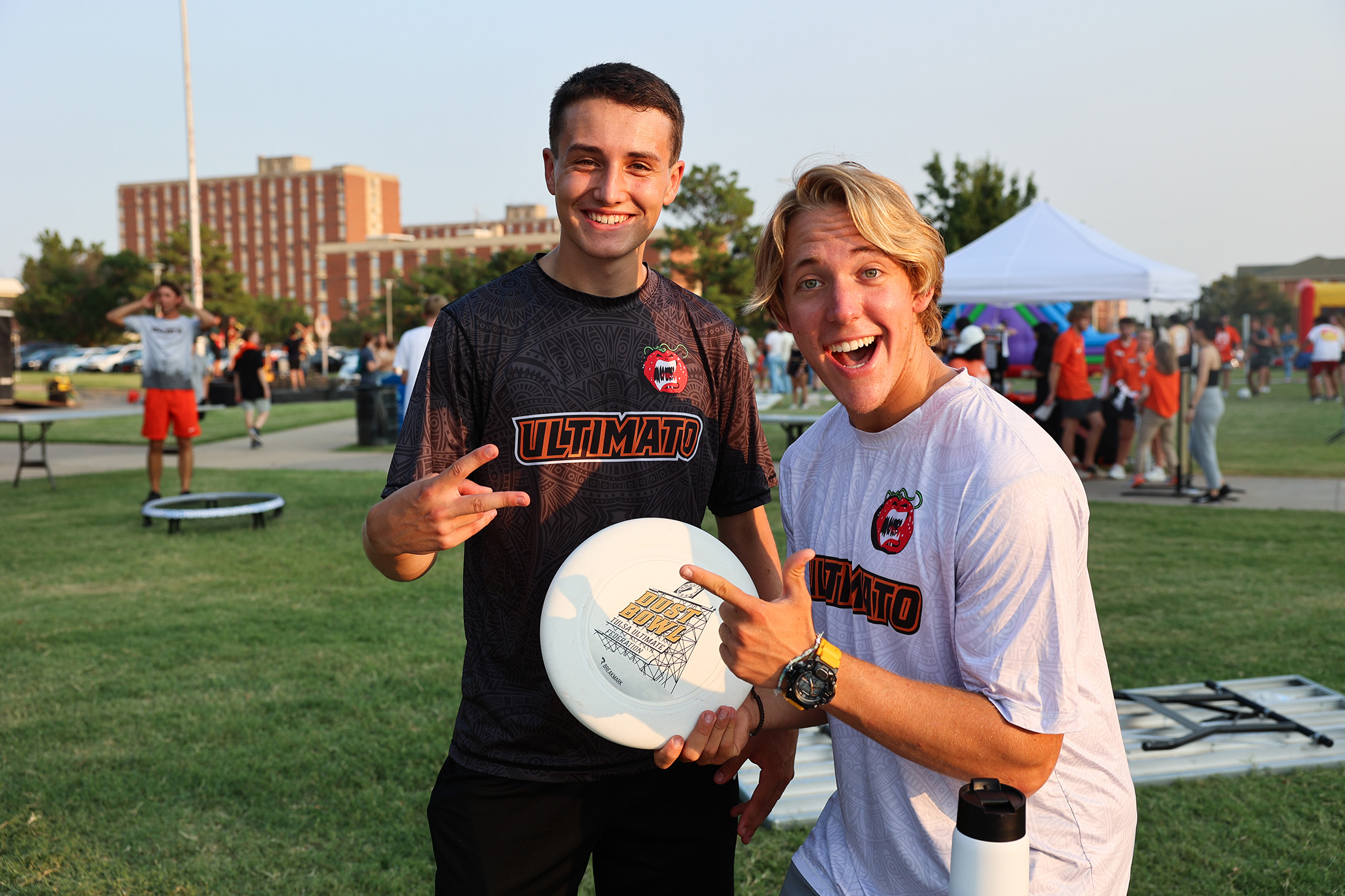 2 smiling men on residential lawn at event